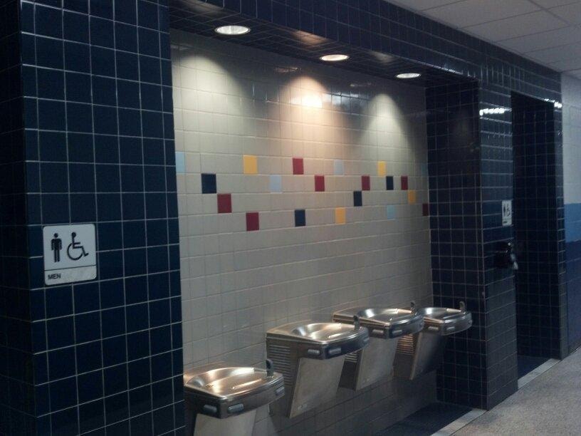 Completed tiled public restroom wall with drinking fountains