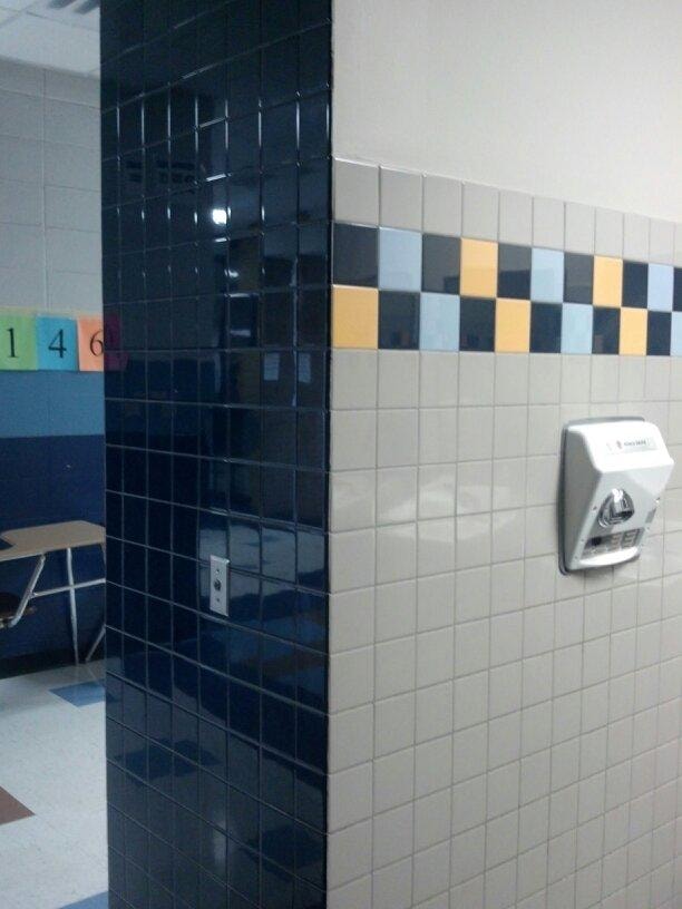 Tiled restroom interior with hand dryer and decorative accents